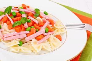 pastaboog met wortelblokjes, salami en doperwtjes foto