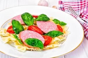 pasta met tomaat, salami en basilicum foto