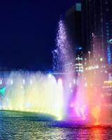 Oezbekistan, Tasjkent - september 27, 2023 een fontein met laser verlichting en licht muziek- in Tasjkent stad park Bij nacht tegen de backdrop van een wolkenkrabbers. foto