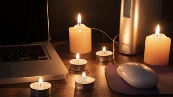 Black Out concept, 6 lit kaarsen verhelderend de werkruimte met een laptop foto