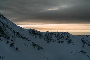 visie van de winter zonsondergang en met sneeuw bedekt bergen foto