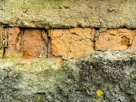fragment van een oude bakstenen gepleisterde beschadigde muur.