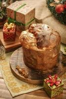 panettone, rozijnen en gekonfijte fruitblokjes op houten snijplank met kerstversieringen foto