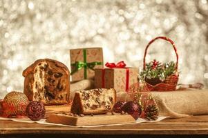 plakje chocolade panettone op houten snijplank met kerstversieringen foto