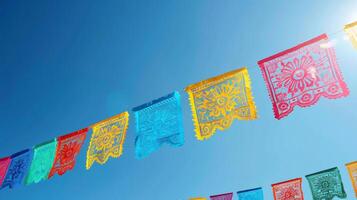 levendig Mexicaans papel picado fladderend tegen een Doorzichtig blauw lucht. cinco de mayo spandoek. foto