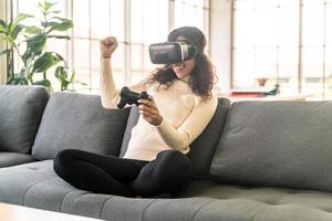 Latijnse vrouw die een virtual reality-headset gebruikt op de bank foto