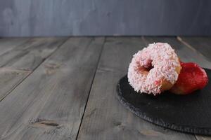 ronde donuts donuts met wit kokosnoot hagelslag Aan grijs achtergrond met ruimte voor kopiëren ruimte tekst. donut dag foto