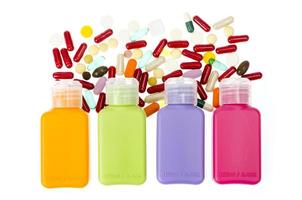 veelkleurige plastic flessen, containers met pillen en capsules geïsoleerd op een witte achtergrond.