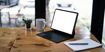 mockup beeld van een zwart tablet met wit blanco scherm Aan houten bureau. foto