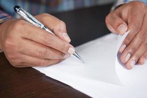 man hand in vulpen schrijven of handtekening op papier. foto