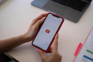 Chiang Mai Thailand - mei 24,2021 . appel iphone met youtube logo Aan de scherm Aan houten bureau. foto