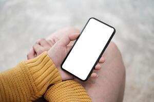 dichtbij omhoog van hand- vasthouden, gebruik makend van cel telefoon met blanco scherm. foto