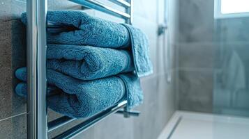 verwarmde het spoor met blauw handdoeken in badkamer met kopiëren ruimte. modern verwarmde handdoek het spoor Aan muur in een sereen badkamer instelling. foto