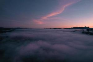 vliegen boven de wolken zonsopgang en mist foto