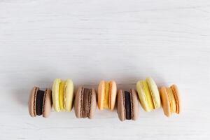 smakelijk Frans macarons Aan een wit houten tafel. wit achtergrond, pastel kleuren. foto