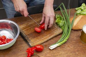 karbonade de groen uien en tomaten en plaats hen in een schaal. bereiden de salade. foto