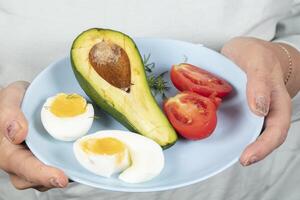 Aan de bord is een gezond ontbijt van eieren, tomaten en avocado. gezond aan het eten. foto