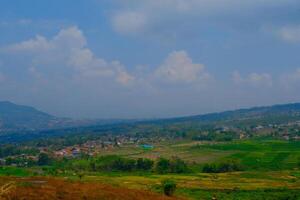 landschap fotografie. landschap visie. toneel- natuur groen en vruchtbaar heuvels. mooi heuvel landschap met blauw lucht achtergrond. bandoeng, Indonesië foto