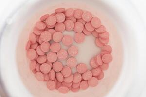 roze pillen in een pot foto