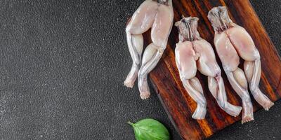 kikker been voedsel rauw vlees vers Koken maaltijd voedsel tussendoortje Aan de tafel kopiëren ruimte voedsel achtergrond rustiek top visie foto