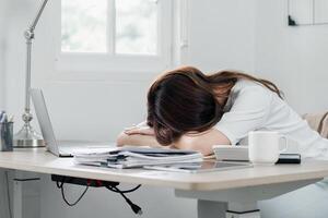 uitgeput professioneel duurt een snel macht dutje Bij haar bureau, temidden van een bezig werk schema. foto