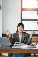 professioneel vrouw mediteert Bij haar werk bureau naar vind kalmte temidden van een bezig schema. foto