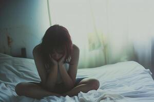 Aziatisch meisje gevoel verdrietig en eenzaam in de slaapkamer onder afm licht foto