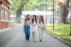 college vrienden wandelen naar klasse samen. Universiteit leerling in campus praten en hebben pret buitenshuis foto