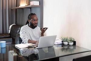 professioneel Mens werken afgelegen van huis met technologie. Afrikaanse Amerikaans mannetje heeft een bedrijf vergadering Aan een audio telefoontje telefoon foto
