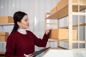 vrouw Aziatisch in een online op te slaan controleren de klant adres en pakket informatie Aan de laptop. online boodschappen doen concept foto