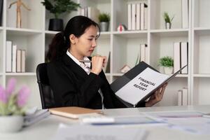 jong bedrijf vrouw Aziatisch of werknemer accounting boekhouding documenten controle financieel gegevens of afzet verslag doen van werken in kantoor met laptop. papierwerk beheer foto