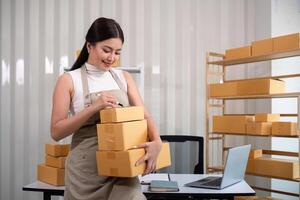 vrouw Aziatisch in een online op te slaan controleren de klant adres en pakket informatie Aan de laptop. online boodschappen doen concept foto