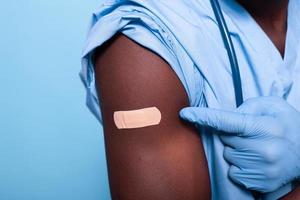 close-up van verbonden vaccin geschoten op arm van man verpleegster foto