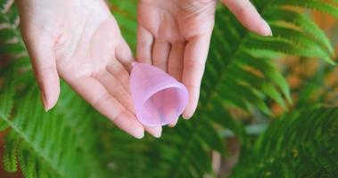 close-up van menstruatiecup in handen van de vrouw. nul afval en milieuvriendelijk concept foto