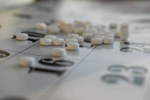 conceptuele foto met pillen. witte pillen op een kalenderachtergrond.