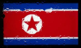 druppels water op de achtergrond van de vlag van Noord-Korea. ondiepe scherptediepte. selectieve aandacht. afgezwakt. foto