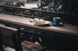 sandwich en warme koffie op houten bar foto