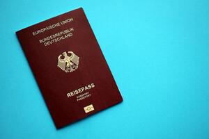 rood Duitse paspoort van Europese unie Aan blauw achtergrond dichtbij omhoog foto