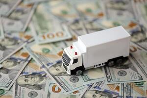 levering vrachtauto Aan honderd dollar rekeningen bankbiljetten. achtergrond van in beweging of vrachtvervoer concept foto