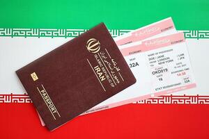 rood Islamitisch republiek van ik rende paspoort met vliegmaatschappij kaartjes Aan Iraans vlag achtergrond dichtbij omhoog foto