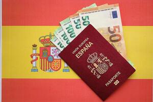 rood Spaans paspoort van Europese unie en geld Aan vlag achtergrond dichtbij omhoog foto