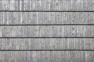 grijs houten dak tegels achtergrond textuur. een dichtbij omhoog van oud grijs dak gedekt met houten tegels foto