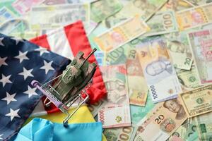 speelgoed- tank Aan ons vlag en oekraïens vlag Aan veel bankbiljetten van verschillend valuta foto