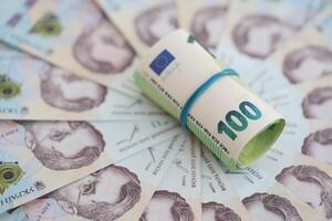 bundel van honderd euro rekeningen leugens Aan veel bankbiljetten van oekraïens hryvnia's. zuinig standaard, crisis en devaluatie van oekraïens nationaal valuta foto