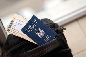 blauw Palestijn Gezag paspoort met vliegmaatschappij kaartjes Aan toeristisch rugzak dichtbij omhoog foto