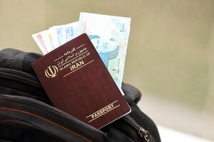 rood Islamitisch republiek van ik rende paspoort met geld en vliegmaatschappij kaartjes Aan toeristisch rugzak foto