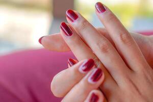 detailopname van een vrouw vinger met haar nagels geschilderd rood. foto