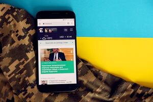 kiev, Oekraïne - 4 kunnen, 2023 espresso TV oekraïens nieuws portaal Aan smartphone scherm met oekraïens vlag en camouflage kleding stof foto