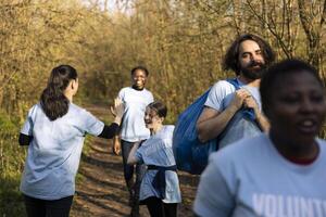 gemotiveerd gelukkig groep van mensen sharing hoog vijf met haar vrienden, afwerking afval schoonmaken van de Woud en besparing de natuur. tevreden activisten feliciteren en loven elk ander. foto