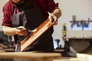 timmerman toepassen was- Aan houten oppervlakte naar voorkomen schade en voorzien laag van bescherming. houtbewerking deskundige in bijeenkomst winkel aan het doen afwerking Aan hout plank, zetten jassen van olie foto